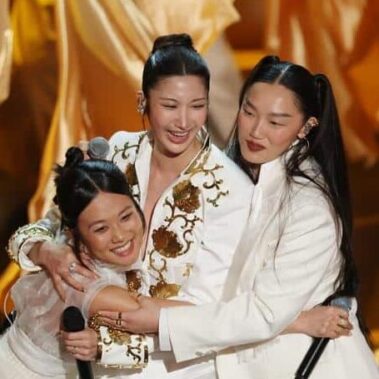 KPop Demon Hunters singers REI AMI, EJAE, and Audrey Nuna embrace after Oscars "Golden" performance.