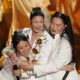 KPop Demon Hunters singers REI AMI, EJAE, and Audrey Nuna embrace after Oscars "Golden" performance.