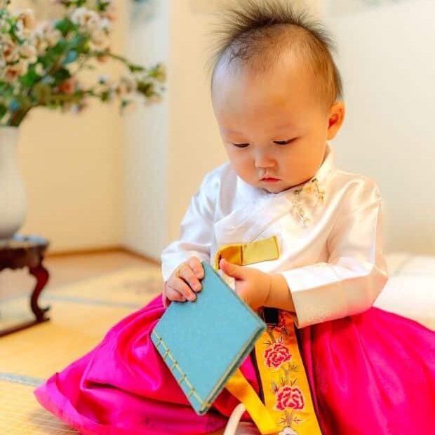 Korean baby playing with a gift
