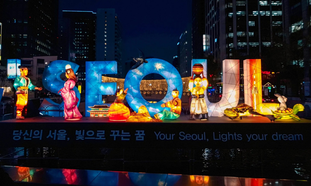 Huge letter lanterns spell out the word Seoul and traditional lantern figures stand in front and next to the letters.