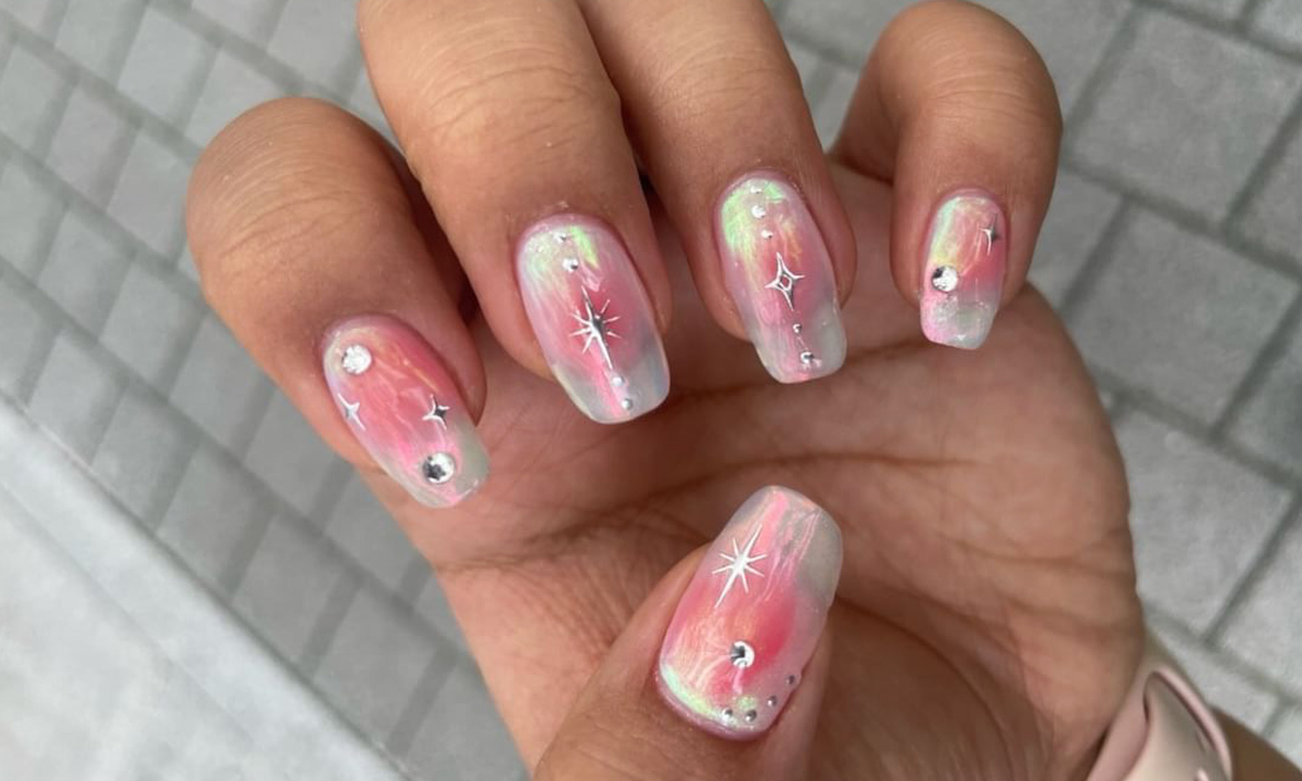 A glowy pink and silver chrome nail design with crystal gems and star stickers. A glowy pink and silver chrome nail design with crystal gems and star stickers.
