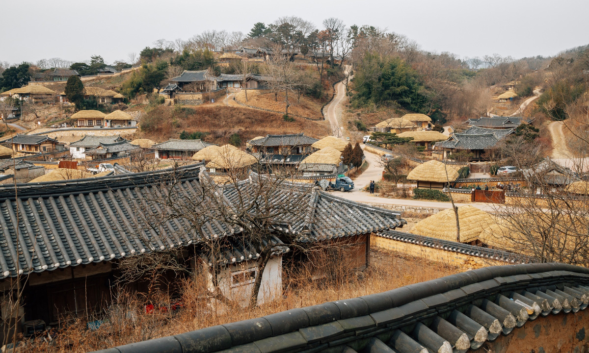 A hill and cloudy day around Yangdong Folk Village. Hanok houses can be seen up close and in the distance.