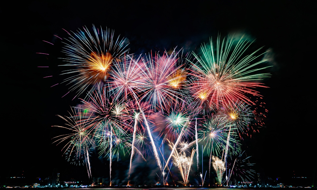 Large fireworks in multiple colors light the dark night skies.