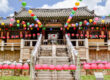 The front of entrance of a Korean Buddhist temple with colorful lanterns hanging above to honor Buddha’s birthday.