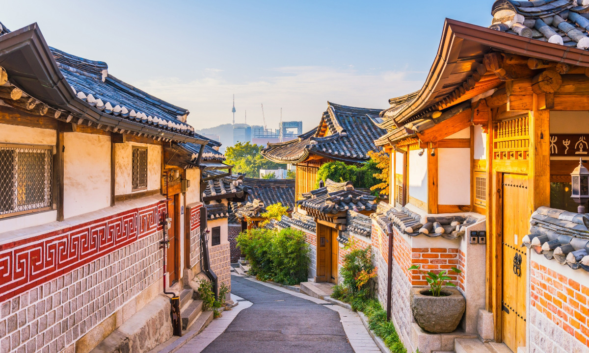 The sunrises over Bukchon Village in Seoul, South Korea as clouds and mist lift from Namsam Tower in the background.