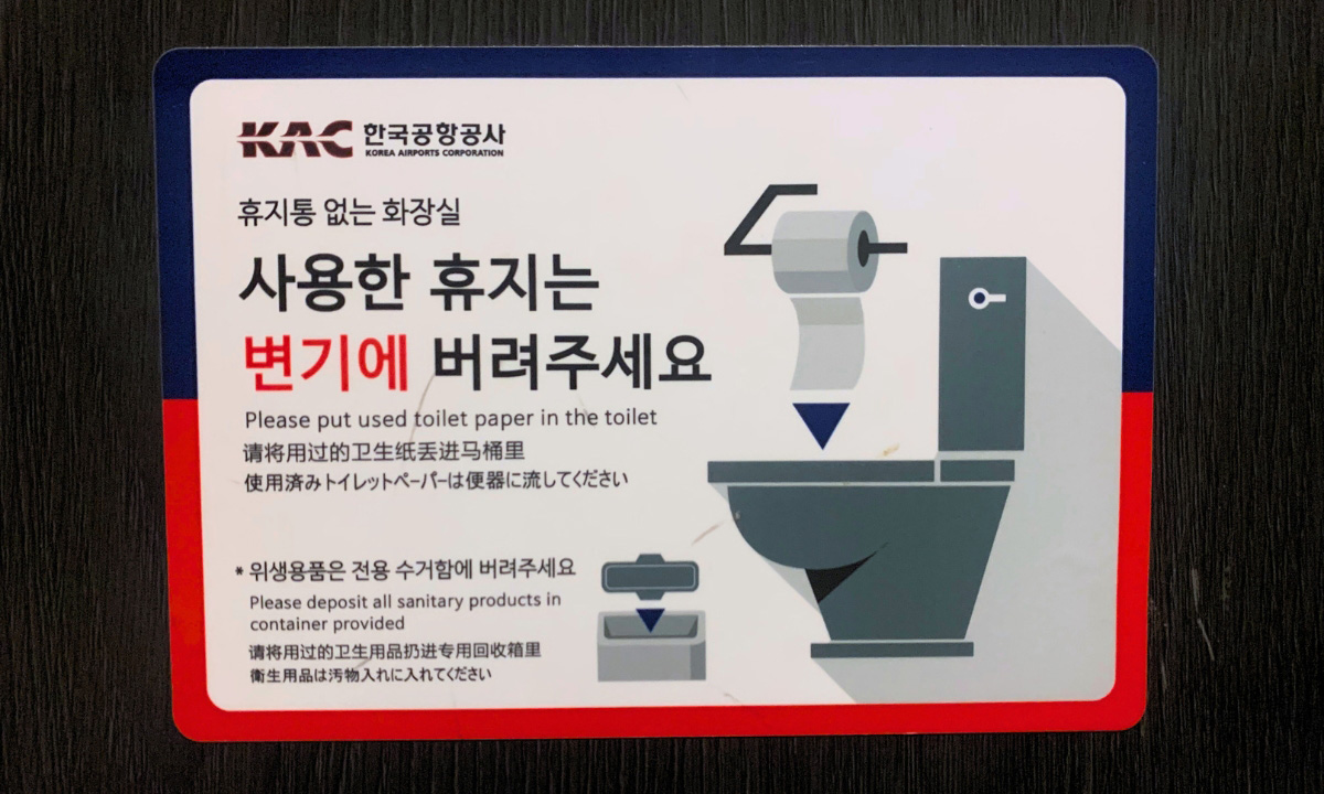 A bathroom sticker that explains that the toilet paper must be thrown away into the toilet.