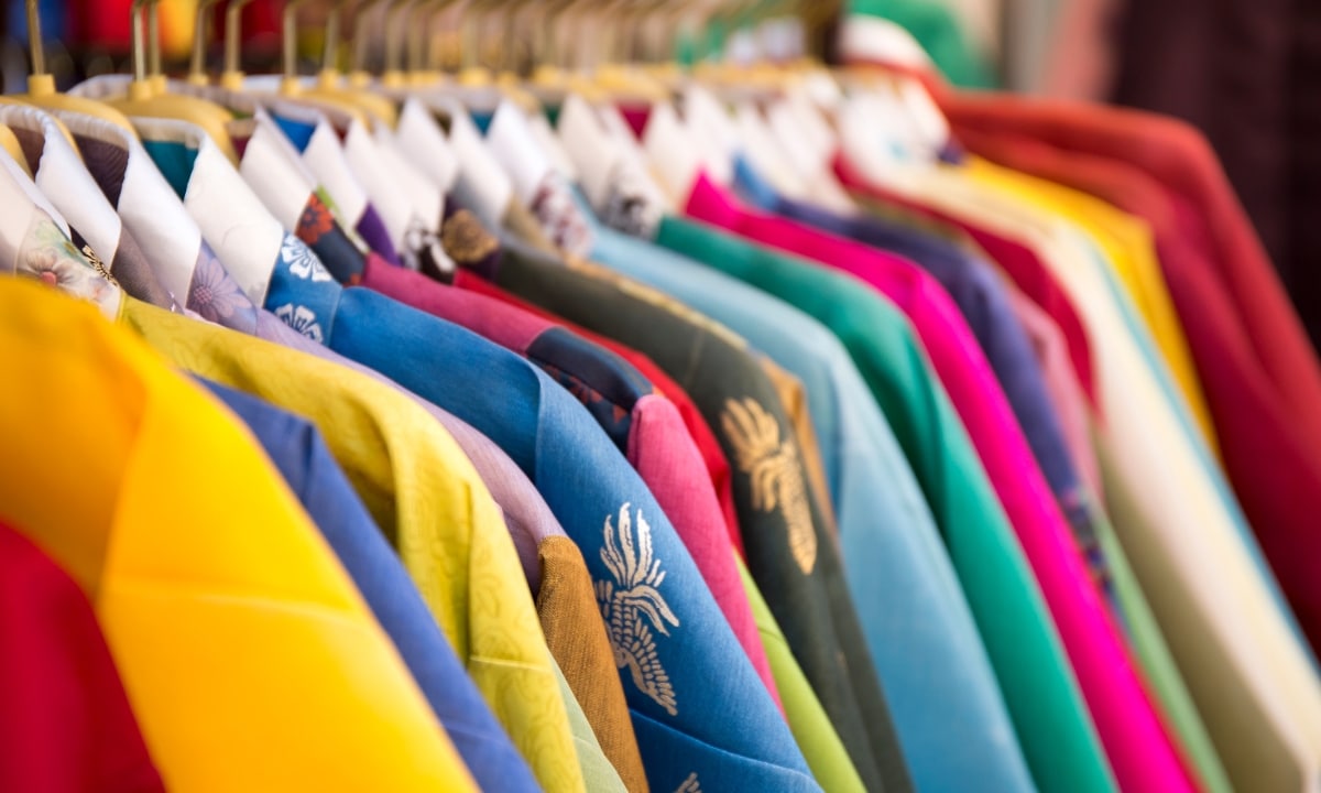 A close-up angled shot of colorful hanbok tops hanging up in a row.