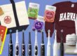 An assortment of popular American gifts for Koreans, featuring a Trader Joe's tote bag, The Little Prince book, Olly gummy vitamins (Daily Energy, Sleep, and Laser Focus), a maroon Harvard sweatshirt, Kiehl's skincare products, and a lineup of sleek electric toothbrushes.