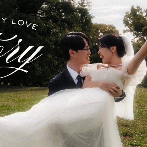 A groom lifts his smiling bride in the air as she stretches out her leg and arm. They are both smiling big, and in a lush green park. Delicate white designs are on the photos corners, and the words "A Happy Love Story" are written on the right.
