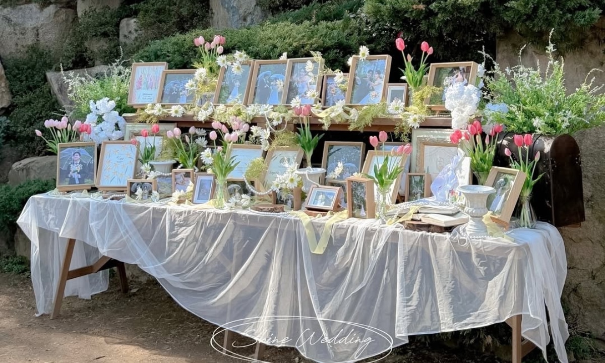 Table of framed photos and decor at a Korean wedding celebration.