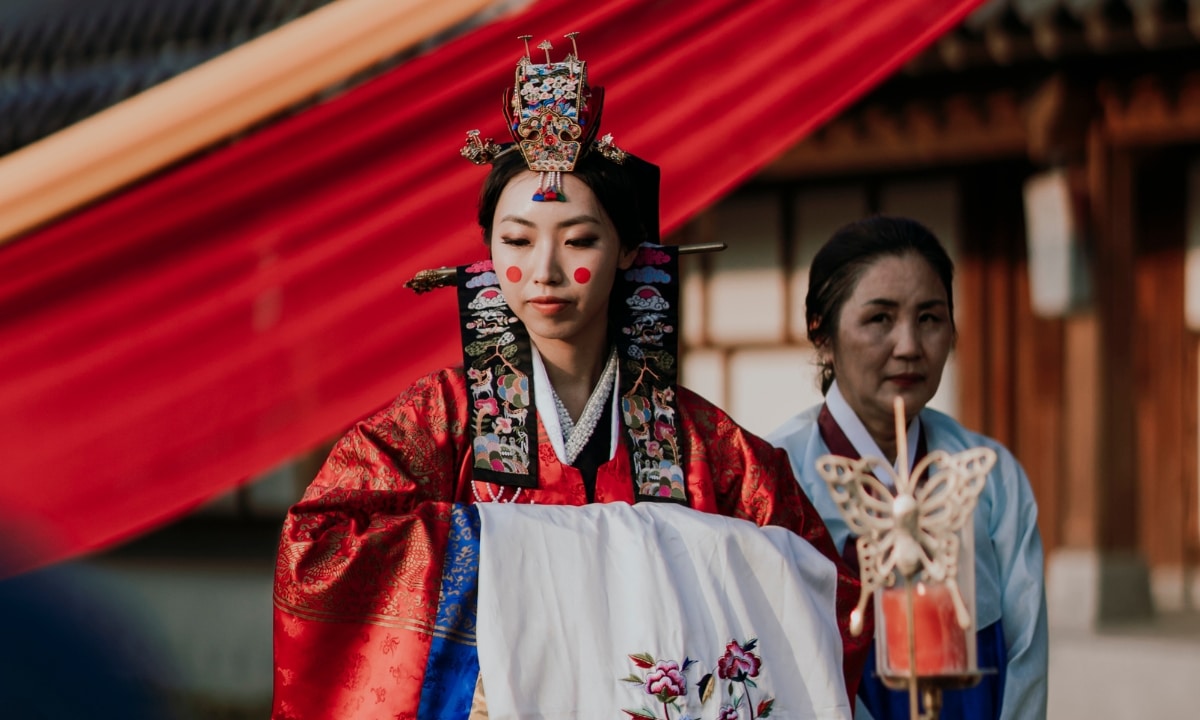 Bride in full traditional Korean wedding attire including headpiece.