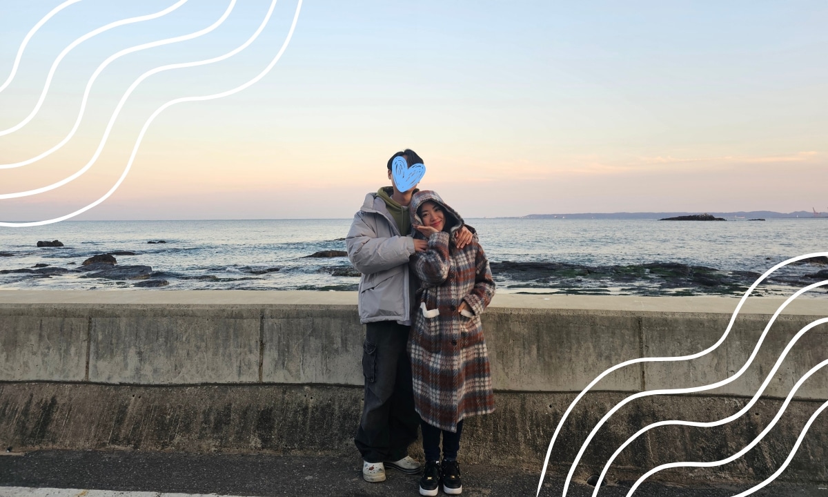 A couple embracing along Pohang’s quiet seaside walkway at sunset.