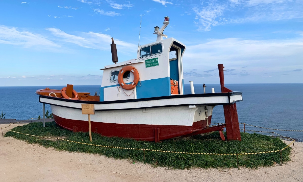 A colorful fishing boat on the grass, evoking scenes from Pohang's coastal town.