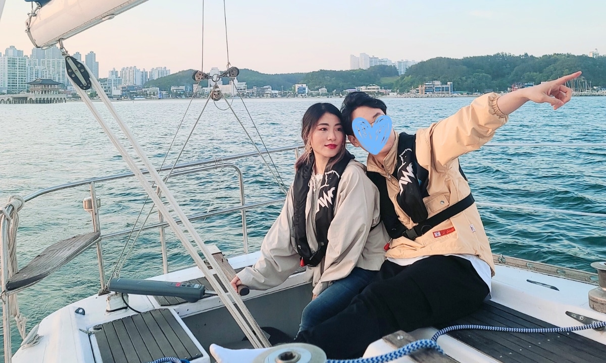 Two people enjoying a yacht ride off the coast of Pohang.