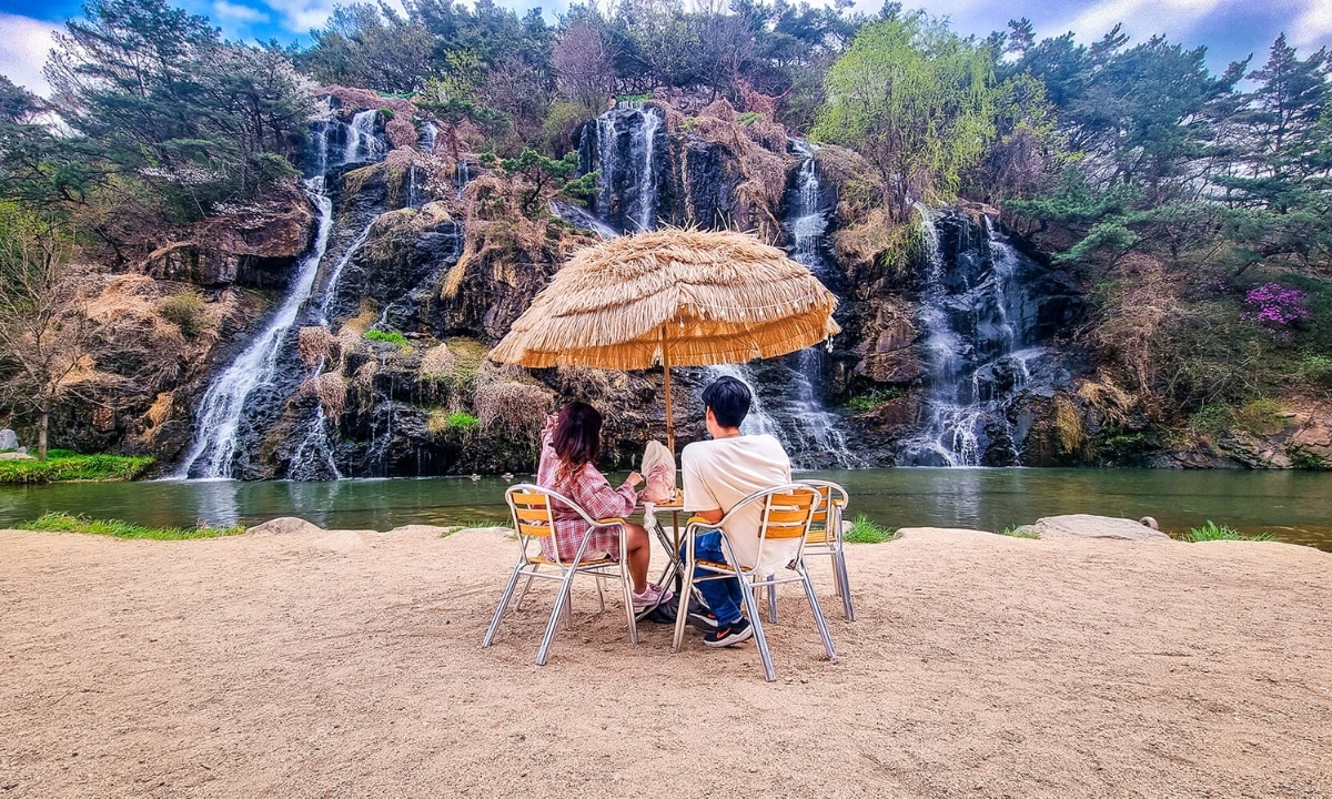 Outdoor seating by a waterfall at Cafe Pokpo, one of Seoul’s unique cafes.